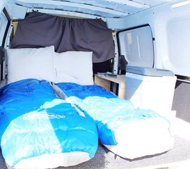 a picture of the mattress and bedding in the nissan nv200 camper van
