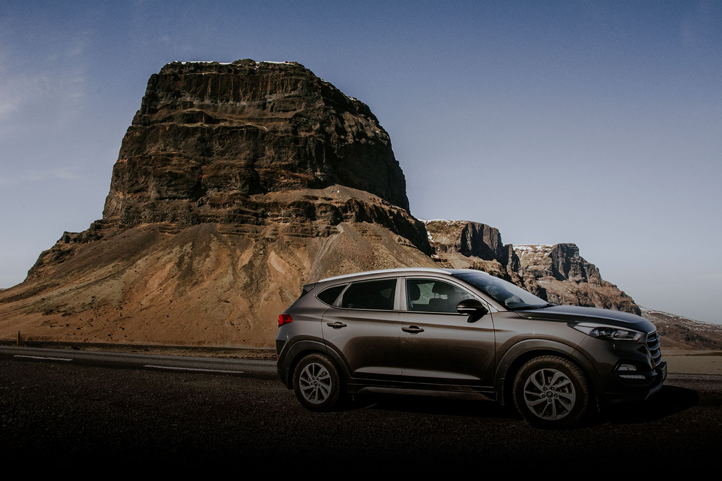 Black Toyota Rental SUV with Rocky Mountain Range Background
