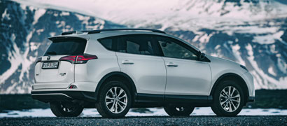 Silver Toyota Rental SUV with Snow Mountains in Background