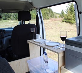 an interior view of the nissan nv200 camper van storage and kitchen essentials