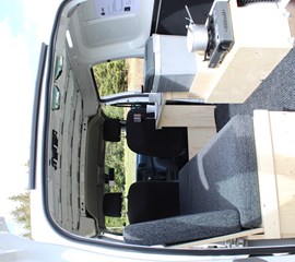 an interior view of the seating area and storage in the back of the nissan nv200