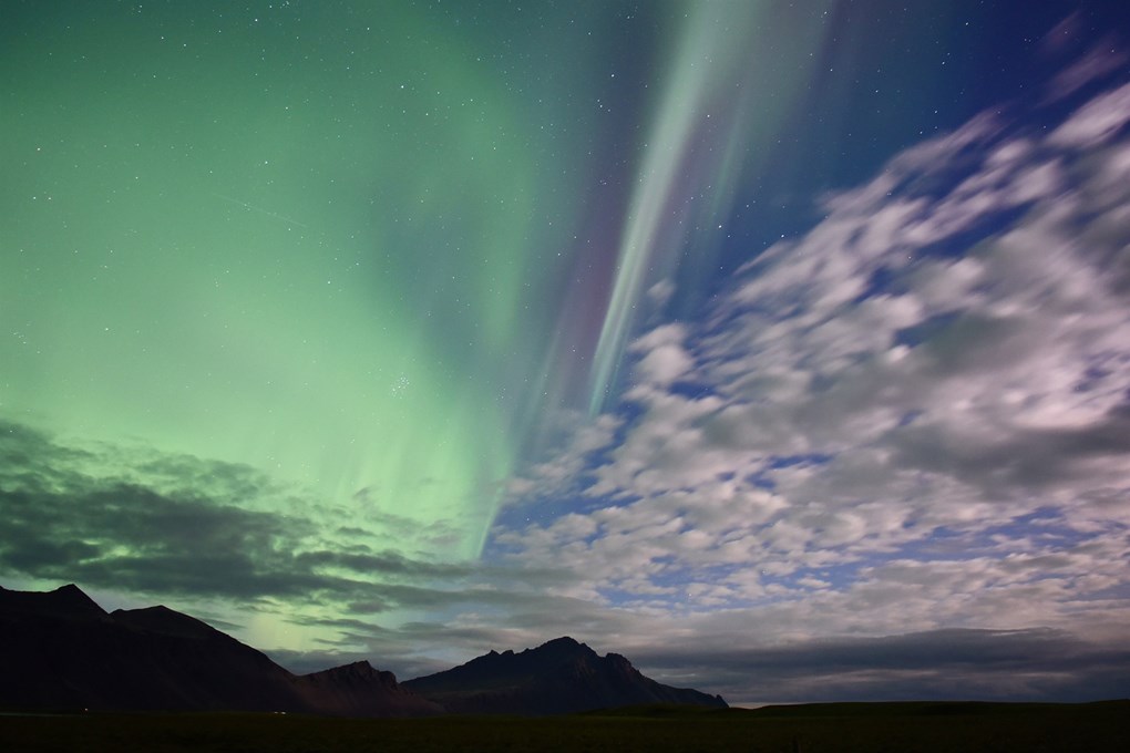 parfois vous pouvez voir la lumière du nord entre les nuages ​​en Islande